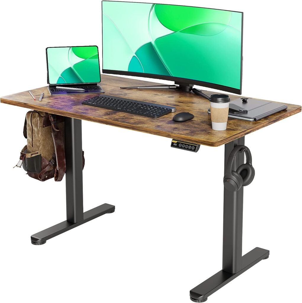 Electric standing desk with a rustic wooden top, featuring an adjustable height control panel on the front. The desk is equipped with a large curved monitor, a laptop, a keyboard, and a mouse. Additional items include a coffee cup, a notebook, and a pen. A backpack is hanging on the left side, and a pair of headphones is hanging on the right side, showcasing the desk's practicality and ample workspace.