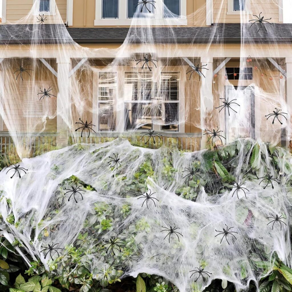 Well lit garden and house covered by fake web and spiders