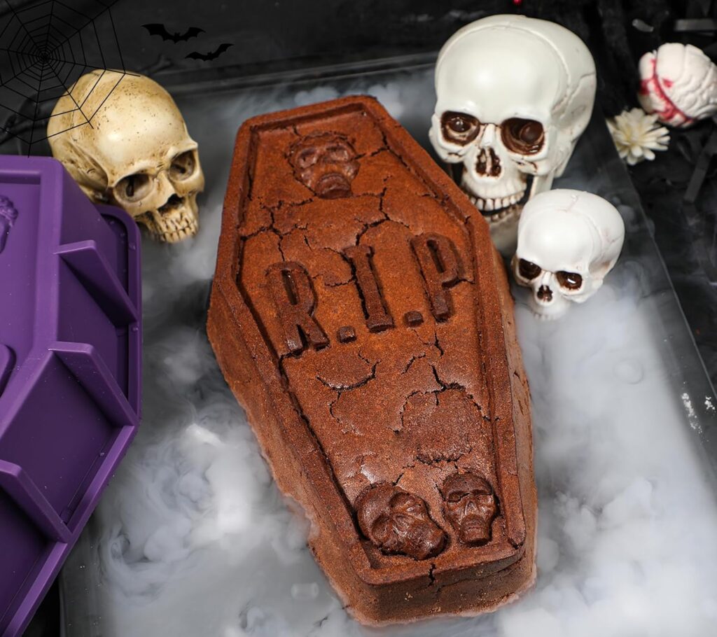 A cake in the shape of a coffin in midst of some fog and skull like decorations